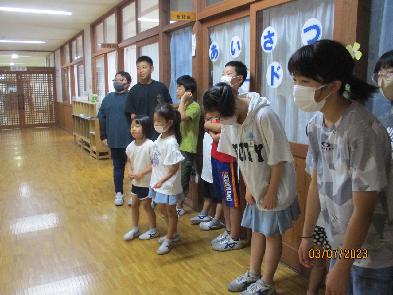 廊下でお辞儀をする子供たちの写真