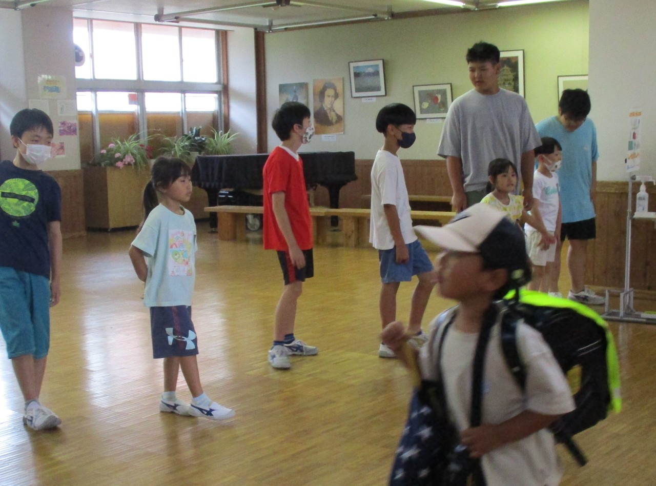 室内に並んで立ち、あいさつをする子供たちの写真