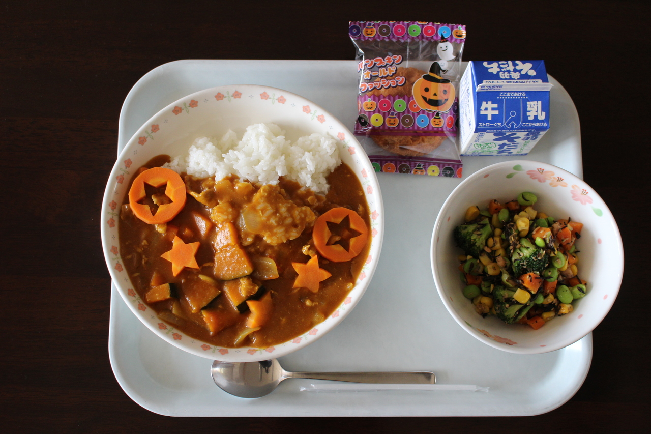 星形にくりぬかれた人参が入ったフルーツカレーと副菜などが並んだ給食の写真