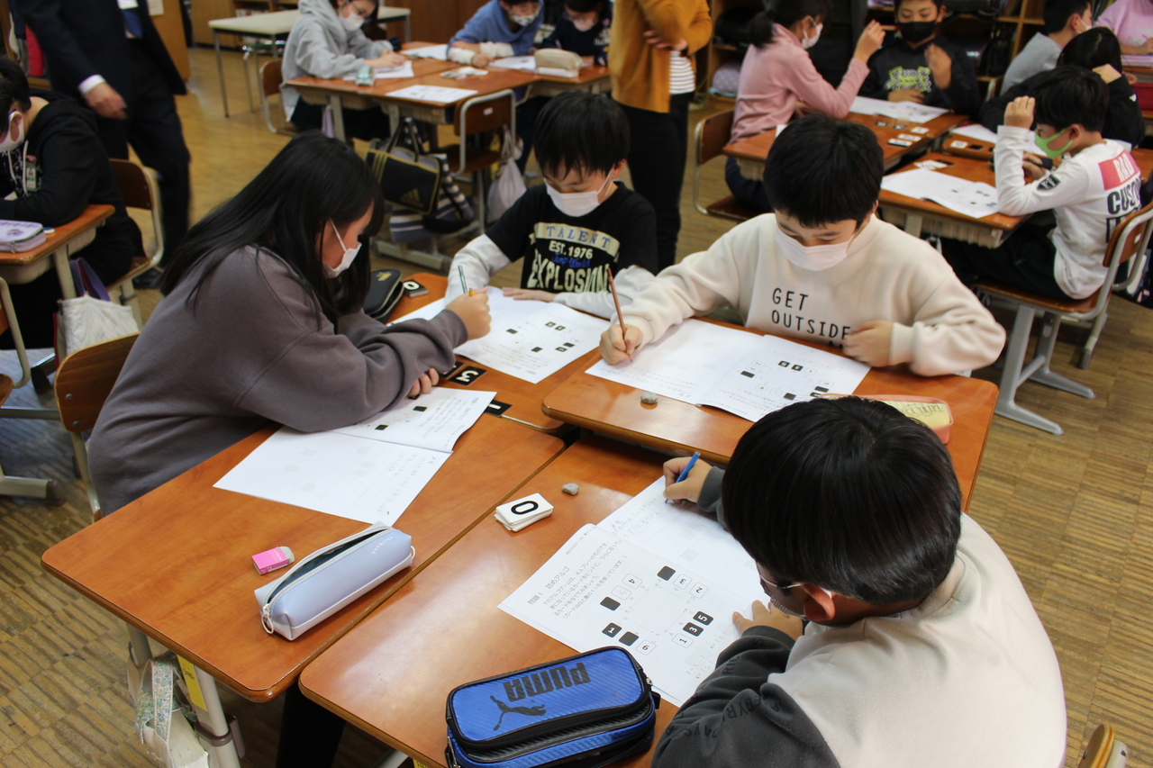 並べた机の上で問題を解き始める子供たちの写真