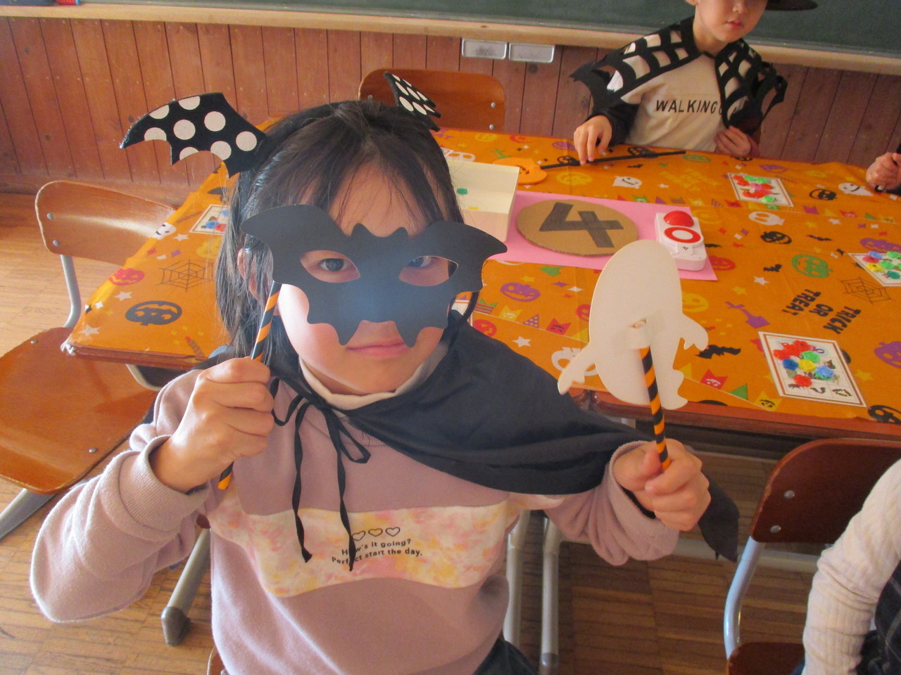 コウモリの形をした黒いマスクをかぶっている子供の写真