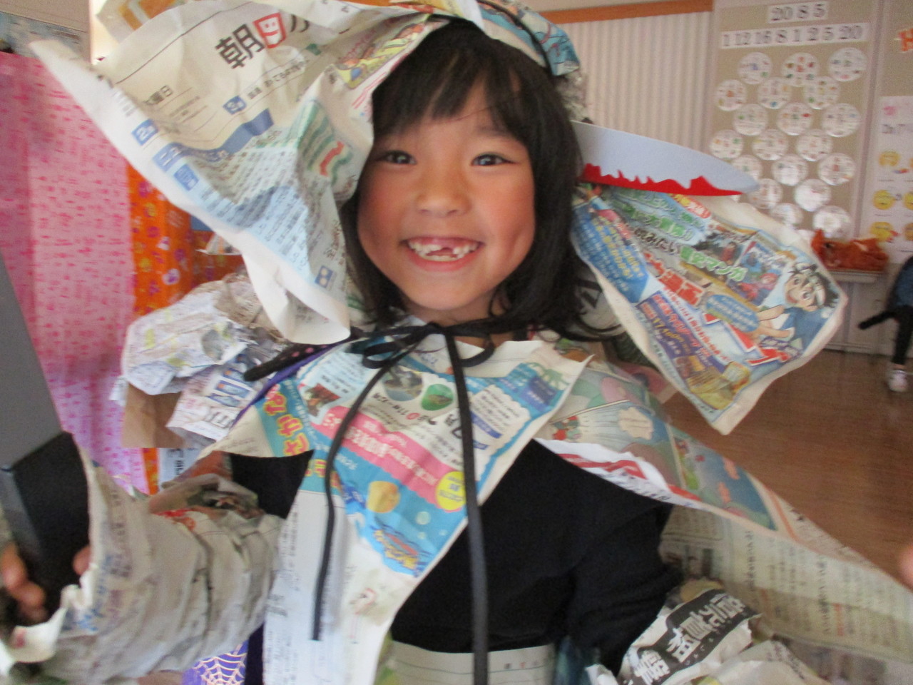 新聞紙で出来た衣装を着ている女の子の写真