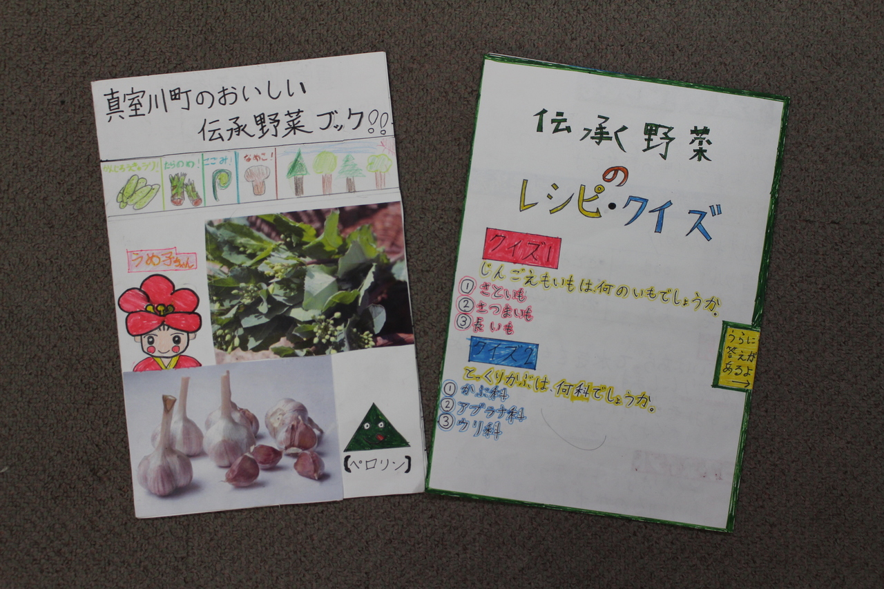 「真室川のおいしい伝承野菜ブック！！」「伝承野菜のレシピ・クイズ」と書かれた手書きパンフレット二冊の写真