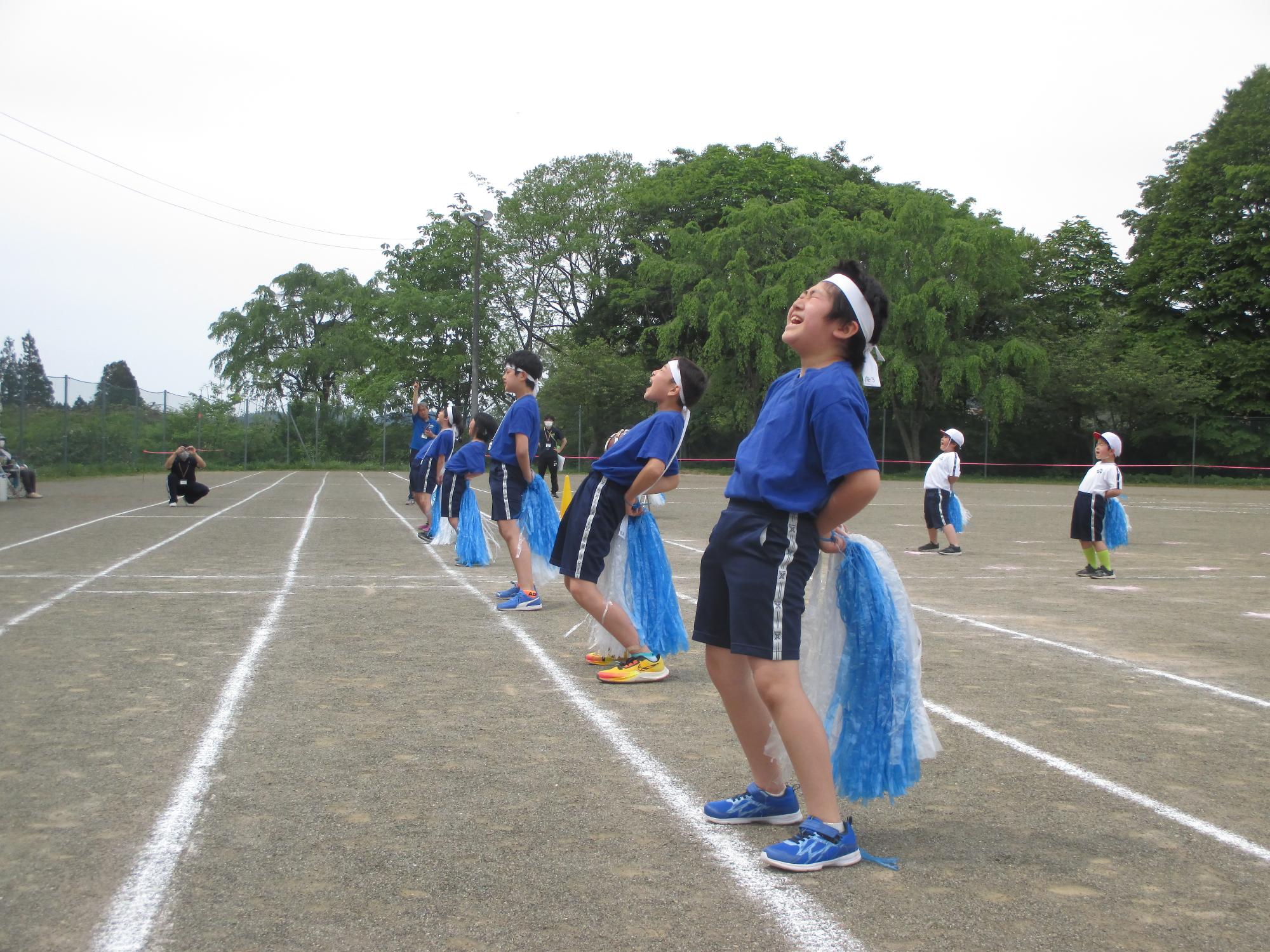 ポンポンを手に胸を反らせながら大きな声で応援する白組児童たちの写真