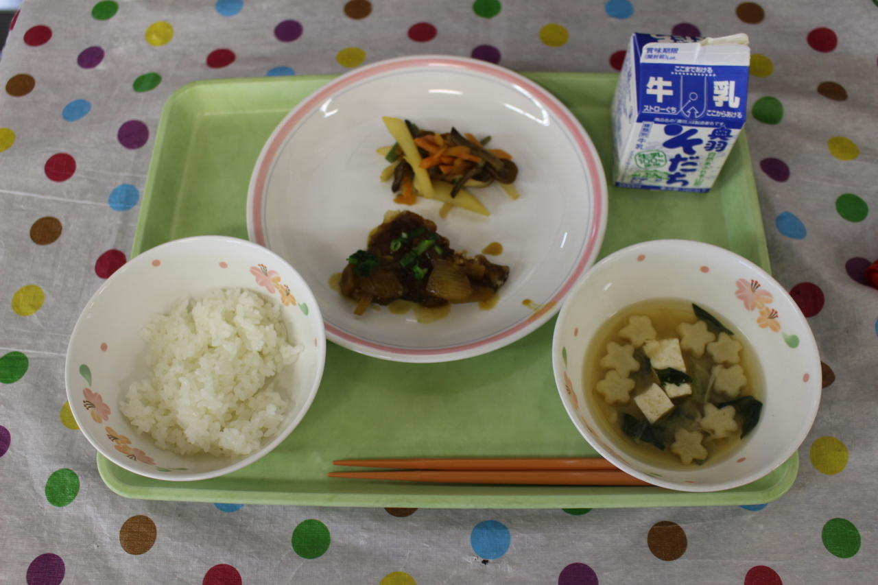 魚の煮つけと、星形の飾り麩の入ったお吸い物などが並べられた給食の写真