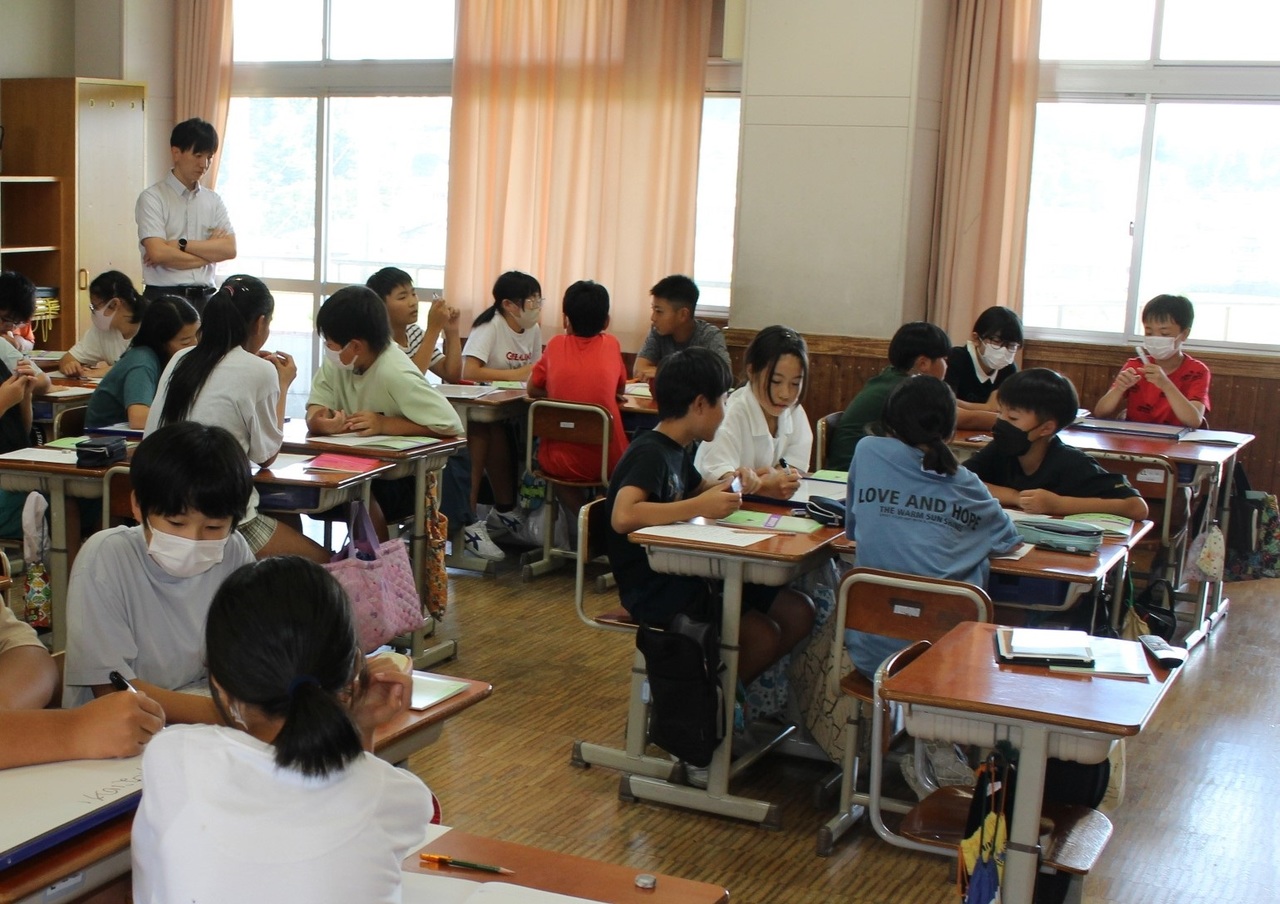 グループごとに机を集めて話し合う子供たちの写真