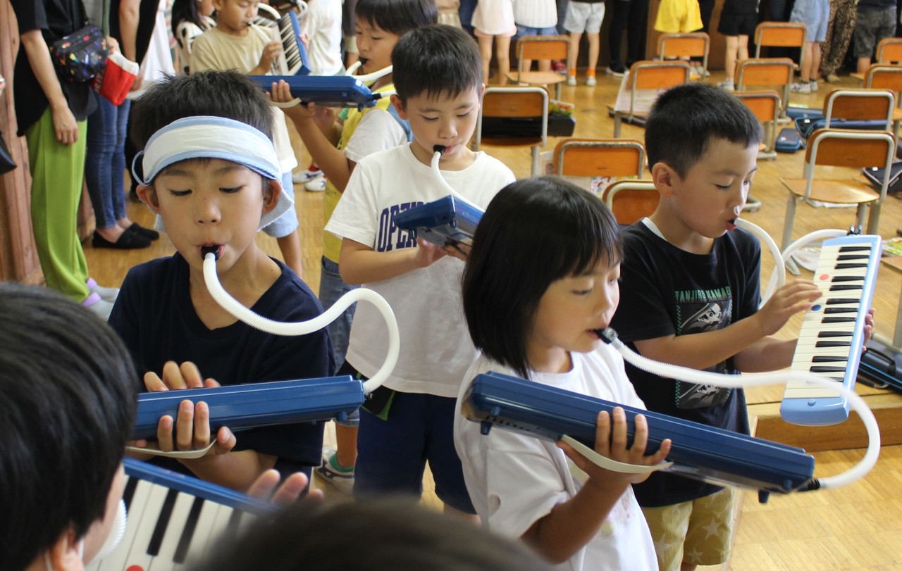 鍵盤ハーモニカを演奏する子供たちの写真