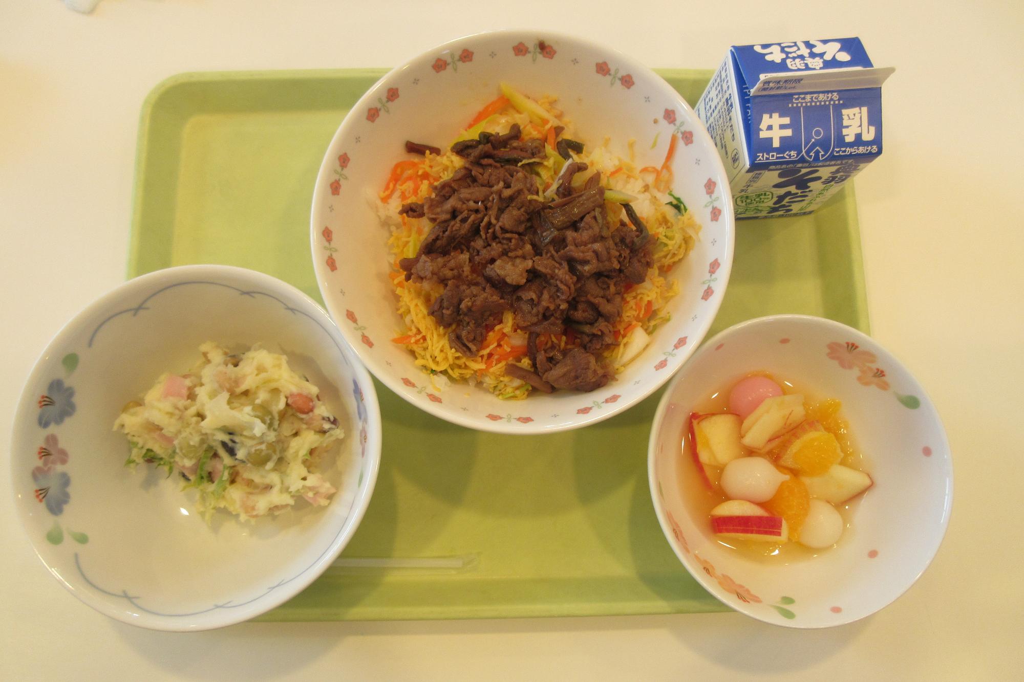 ビビンパどんぶりと伝承豆とたらの芽のポテトサラダとりんごと白玉もちのフルーツポンチと牛乳の写真