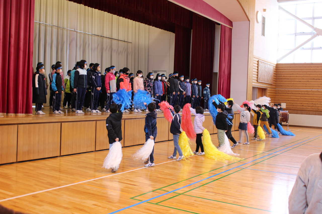 カラフルなポンポンで演技をしている児童たちの写真