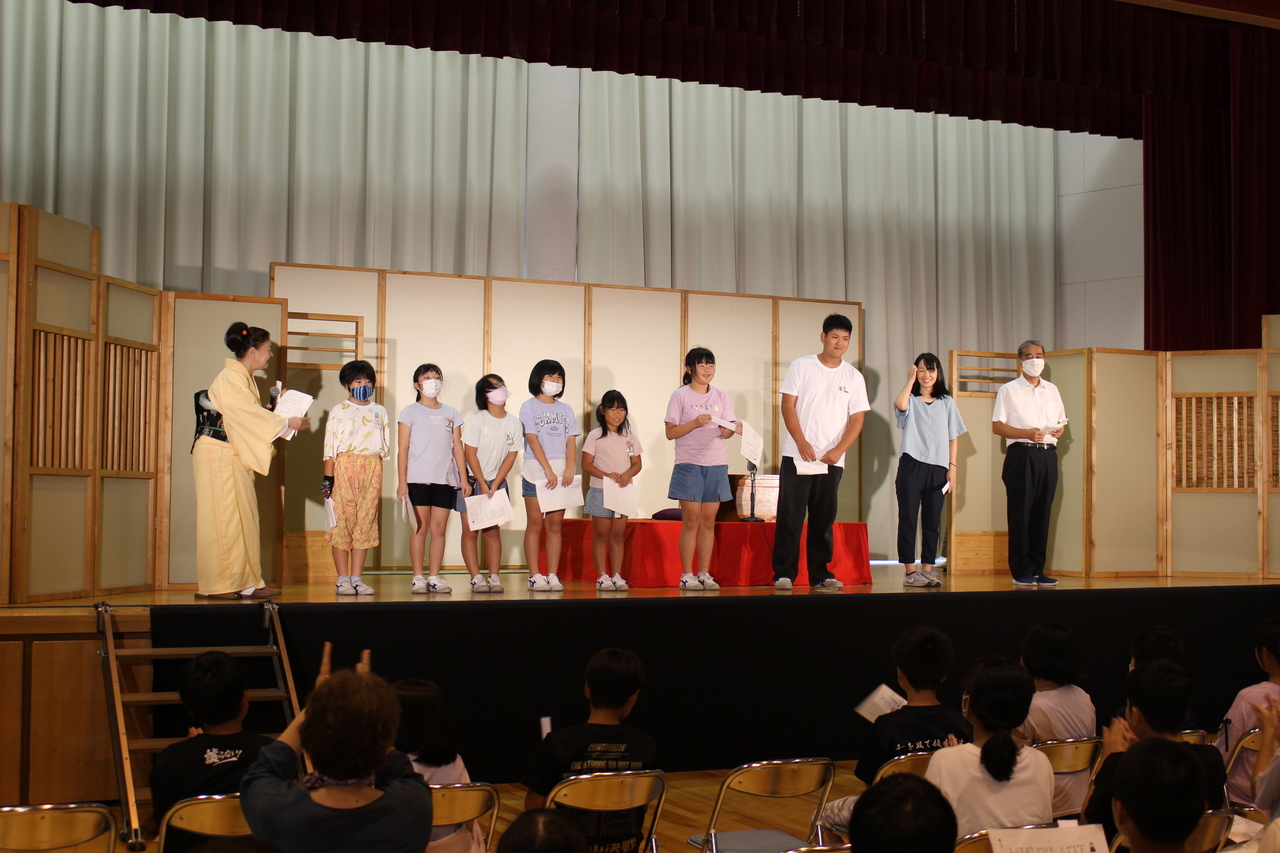 舞台の上で並んで挨拶をする子供たちの写真