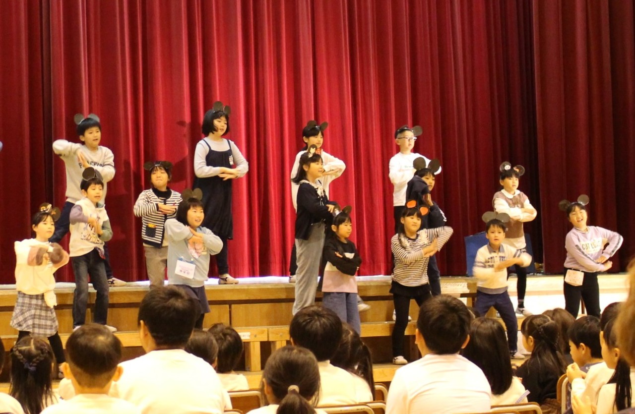 黒い丸が2つついたカチューシャをつけながら踊る子供たちの写真