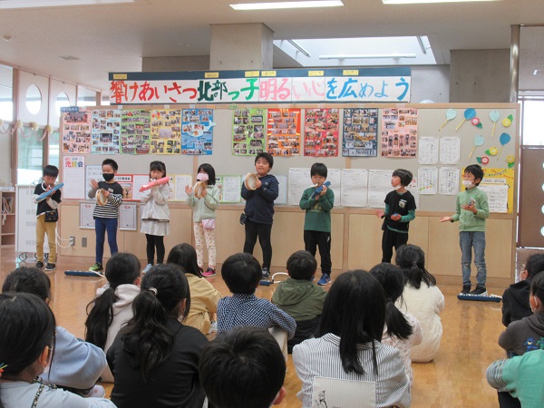 楽器を持っている8人の子供たちが楽器演奏を披露している写真
