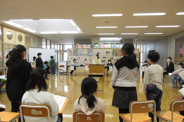教室で円になって並ぶ椅子に座る子供たちの内、数名が立っている写真