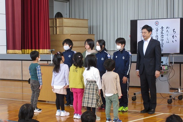 教壇の前に並んで立つ子供たちの写真