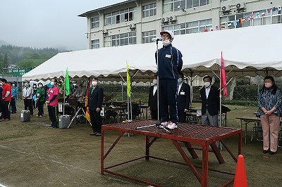 朝礼台の上で開会の宣言をする代表の男子児童の写真