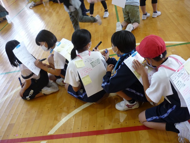 前の背中の画用紙に運動会の感想を書く生徒たちの写真