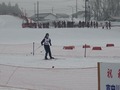 一生懸命平らな雪原をスキーで進む児童の写真