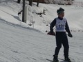 緩やかな坂を体を開いて滑り降りる児童の近影写真
