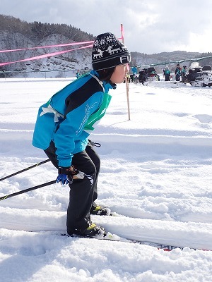 腰をかがめるように少し低い姿勢で滑る児童の写真