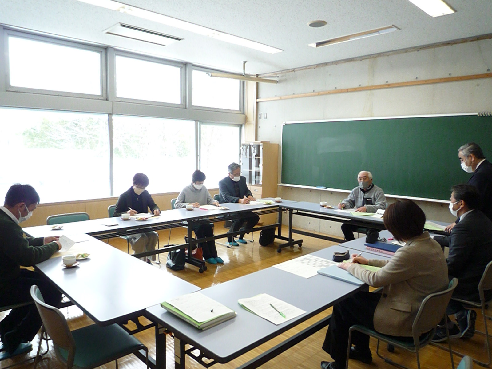 円形に並べられた机に座って話し合いをする運営協議会メンバーの写真
