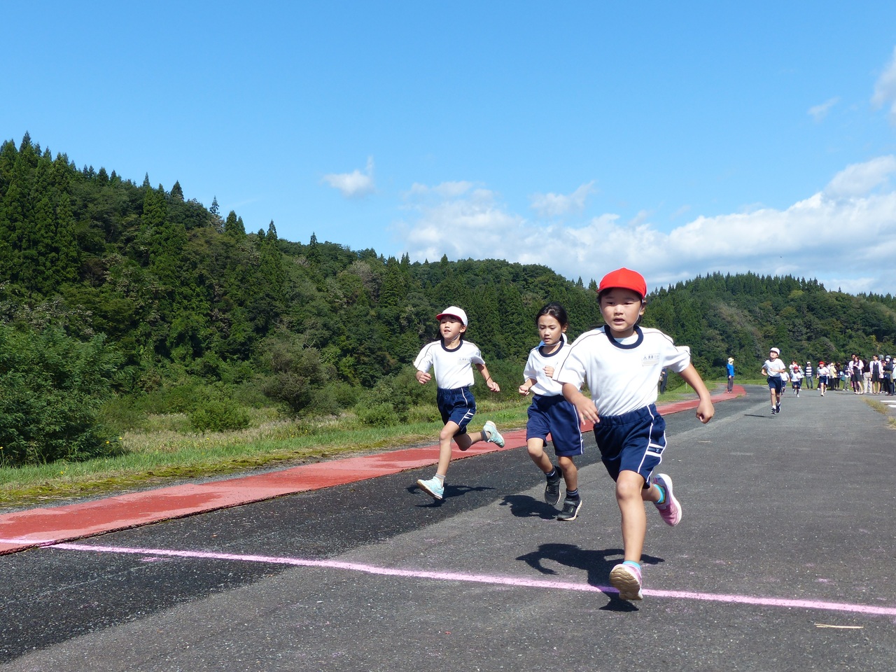 道路の上に引かれた白線を越える子供たちの写真