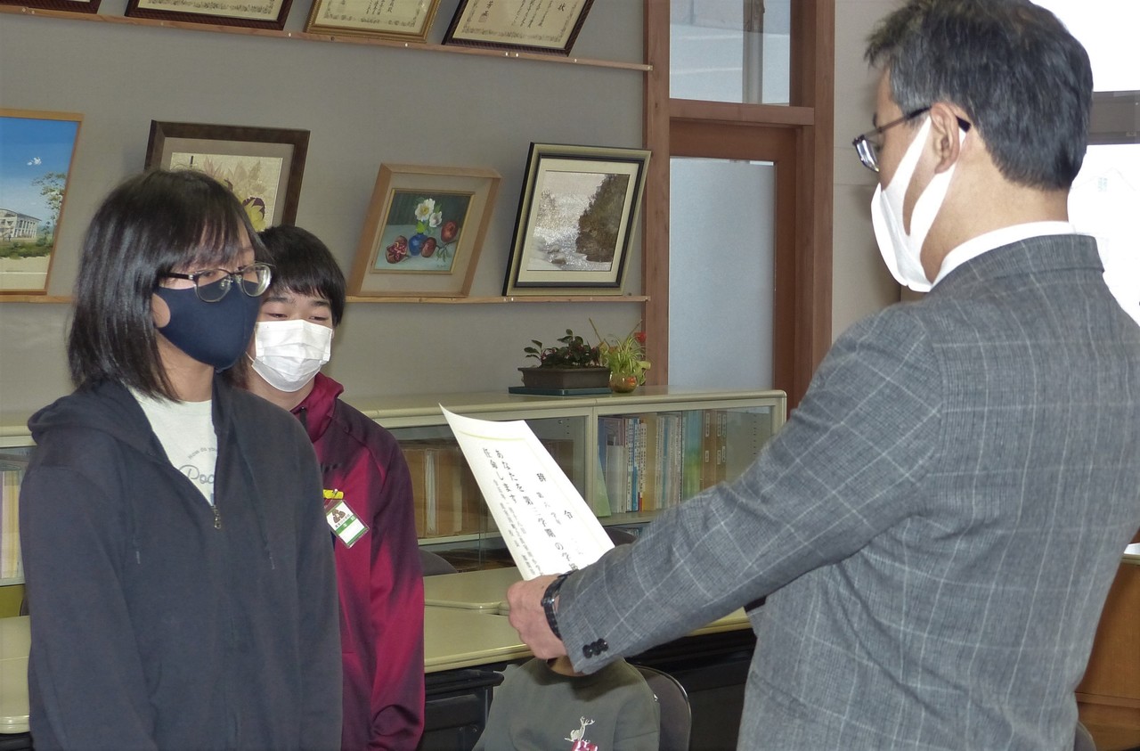 子供に賞状を差しだしているスーツ姿の男性の写真