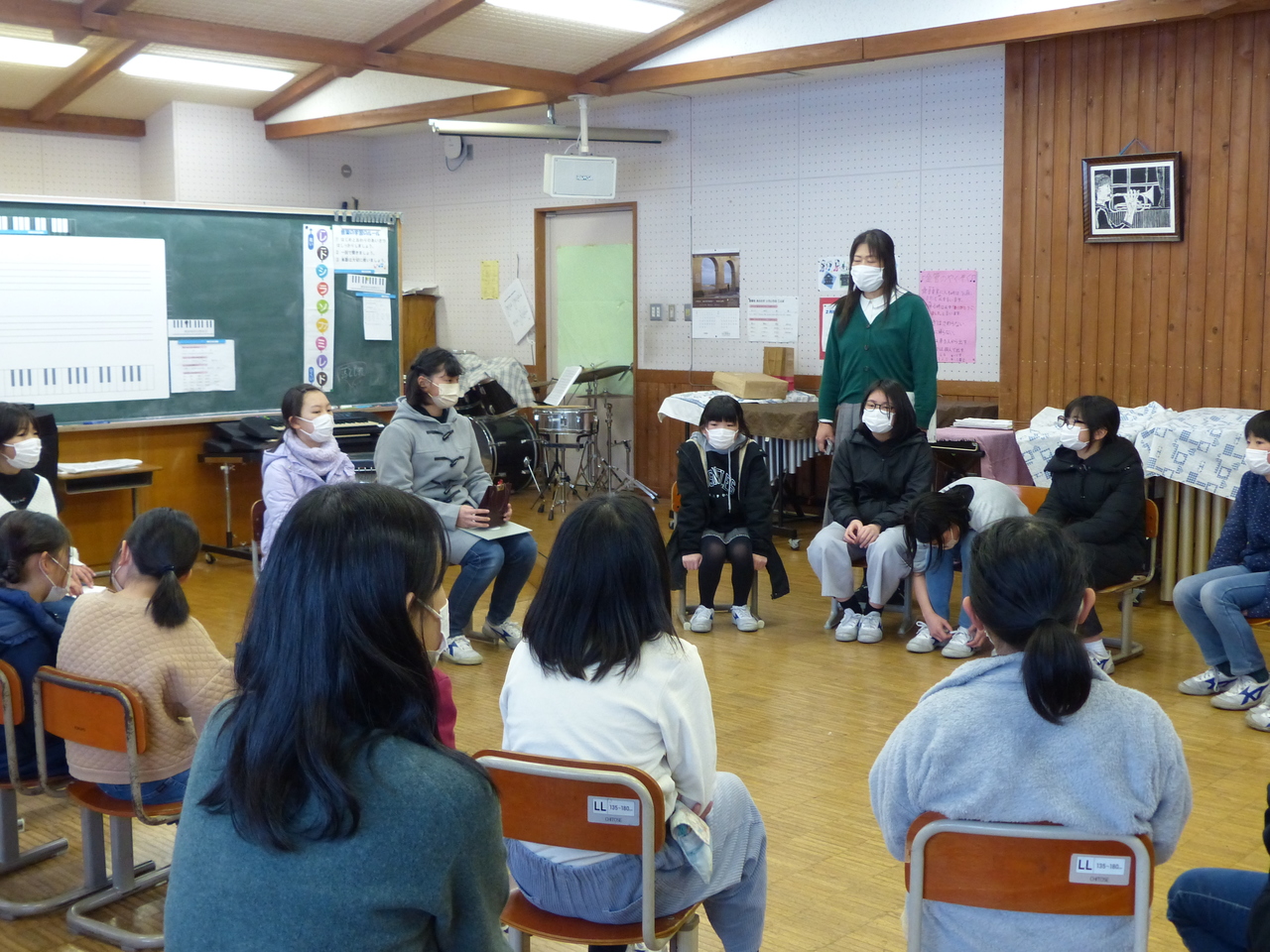 円状に並べた椅子に座っている女子児童たちの写真