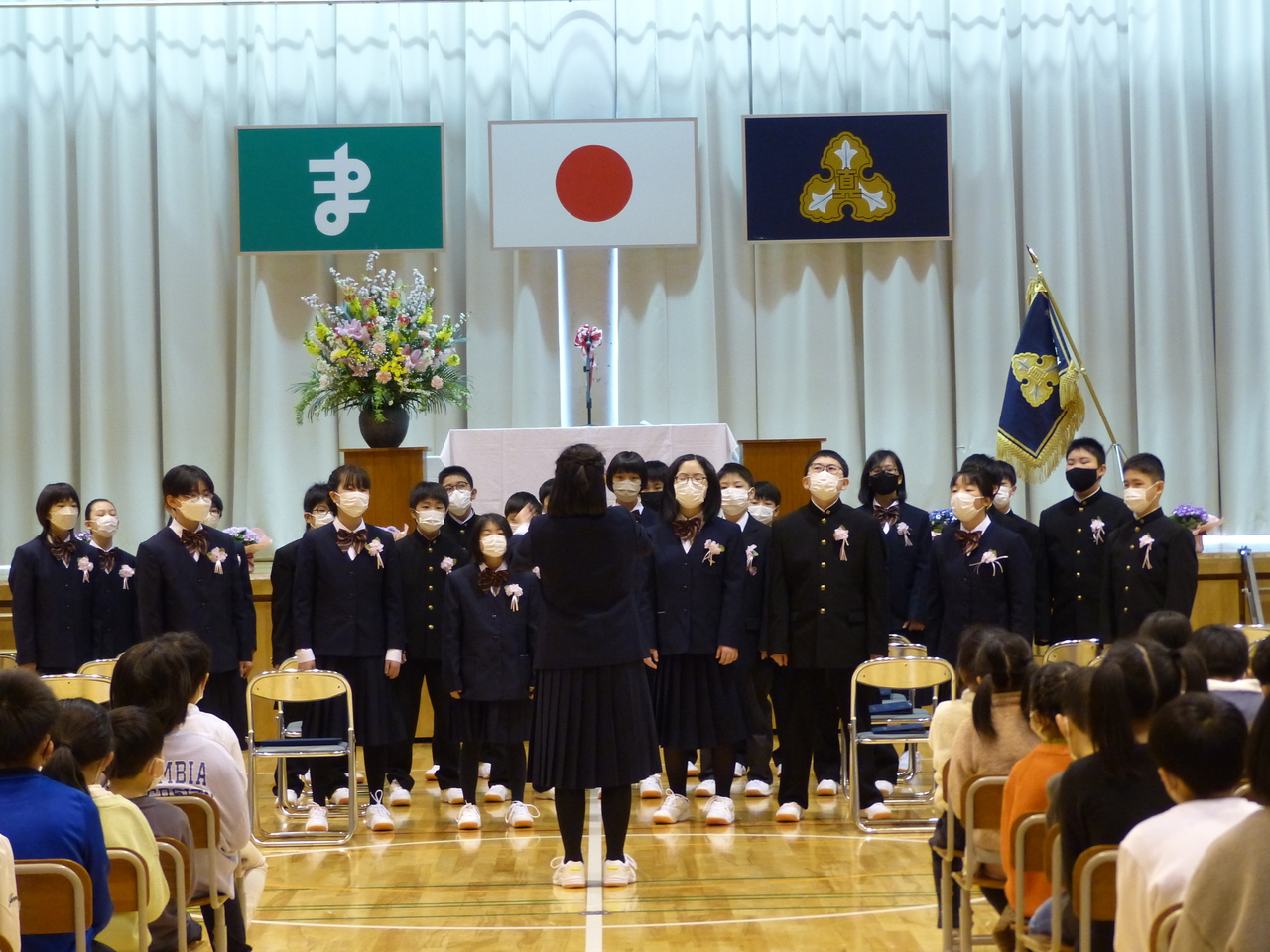 女子生徒の指揮で歌っている児童たちの写真