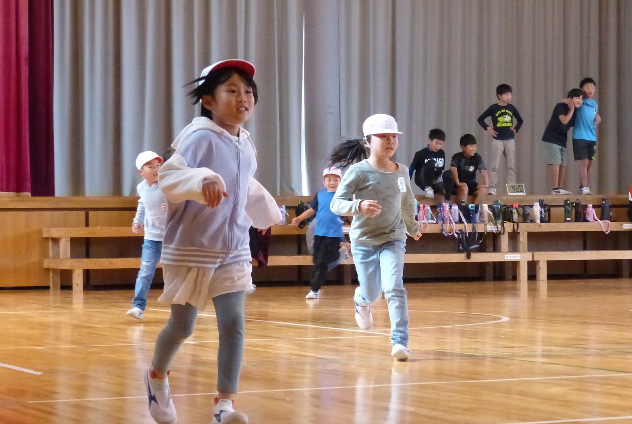 体育館の中で走っている児童たちの写真