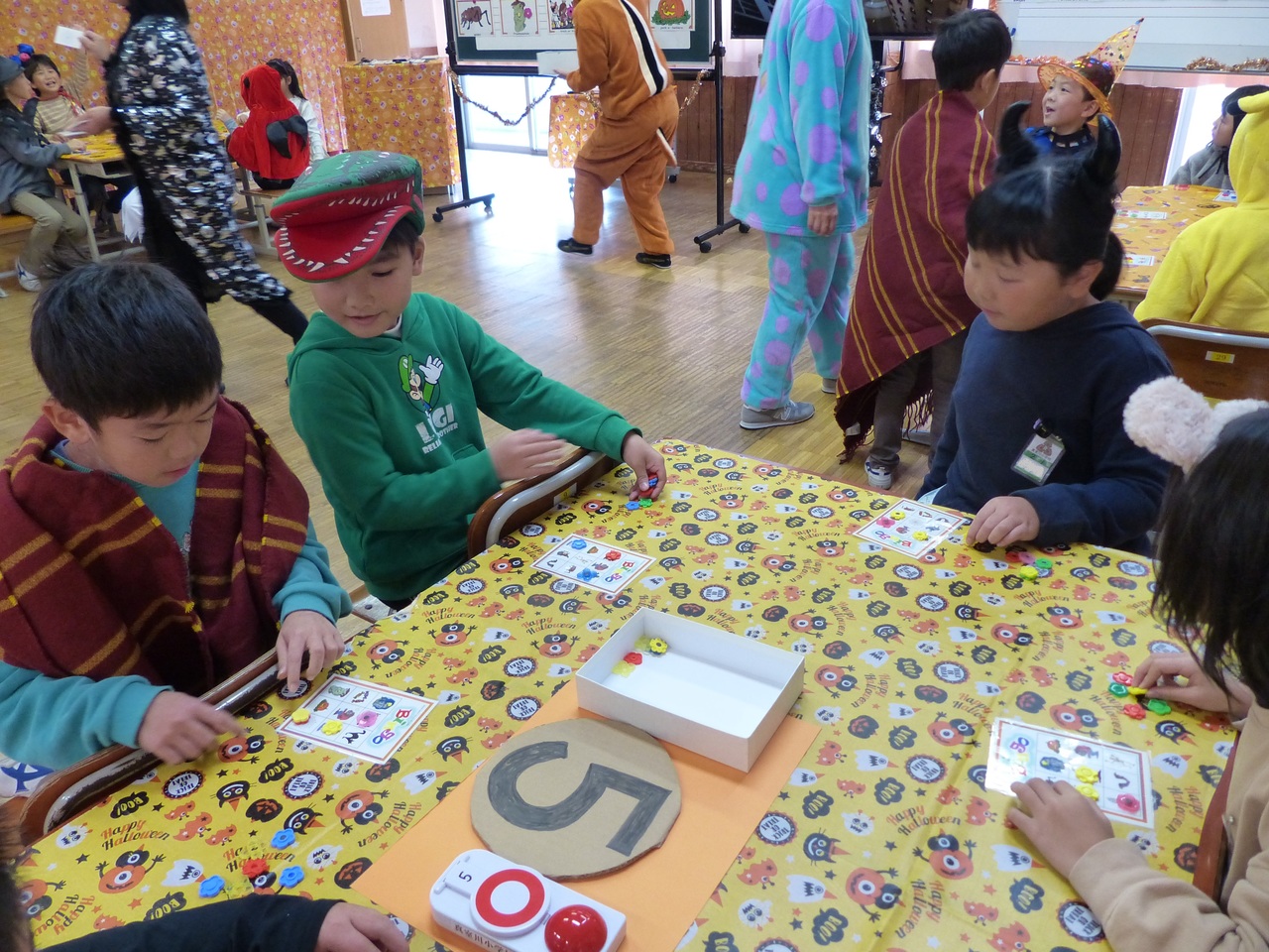 おはじきとカードを使ったゲームで遊んでいる子供たちの写真