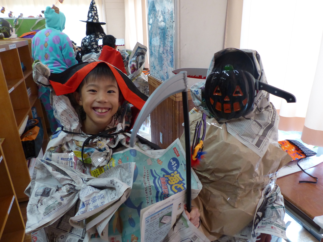 新聞紙や古紙を使った衣装を着ている二人の子供の写真
