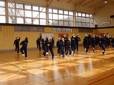 体育館で大きな動きをしながら楽しくダンスする児童たちの写真