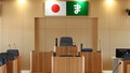 国旗と真室川町の「ま」をモチーフにした町章がある真室川町議会会議棟のバナー（注意（免責）事項 あらかじめよくお読み下さい）