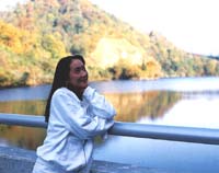 梅花里湖を背景に女性が手すりに寄り添って立っている様子の写真
